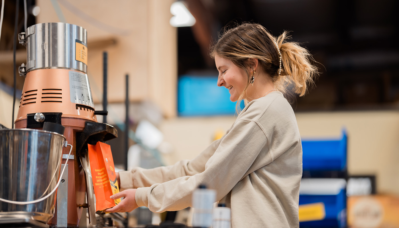A student packing a bag of Desert Sun coffee